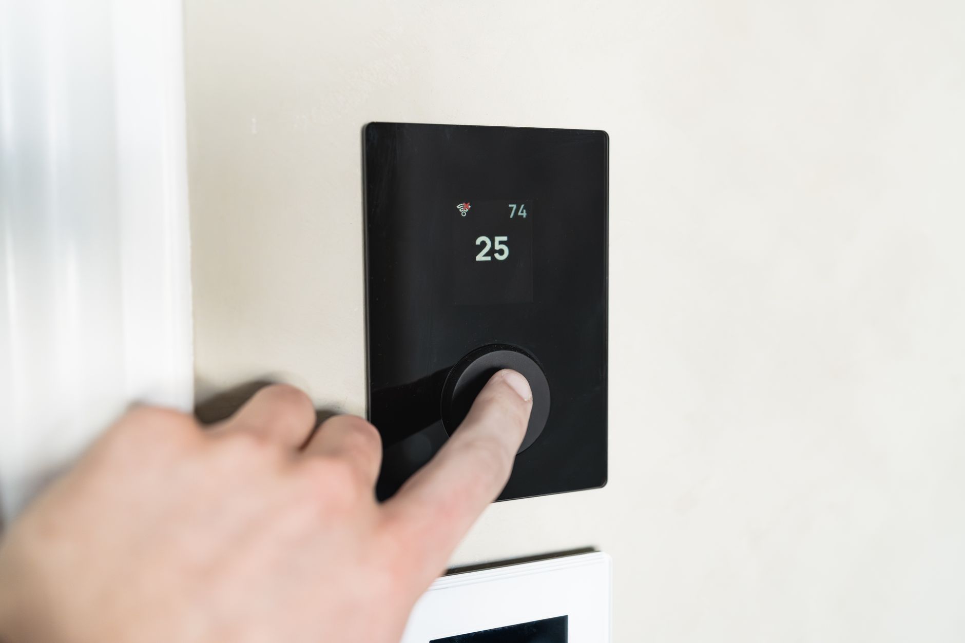 a modern smart thermostat on a wall with digital display showing energy usage statistics